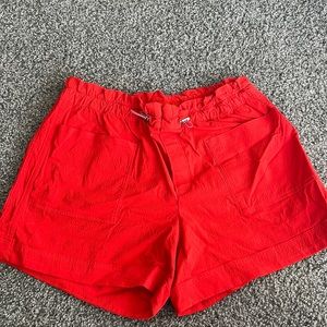 Athleta, women’s 8T shorts. Orange/red color